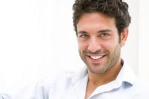 Closeup of happy young man looking at camera at home