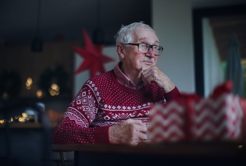 A lonely senior man in a holiday sweater